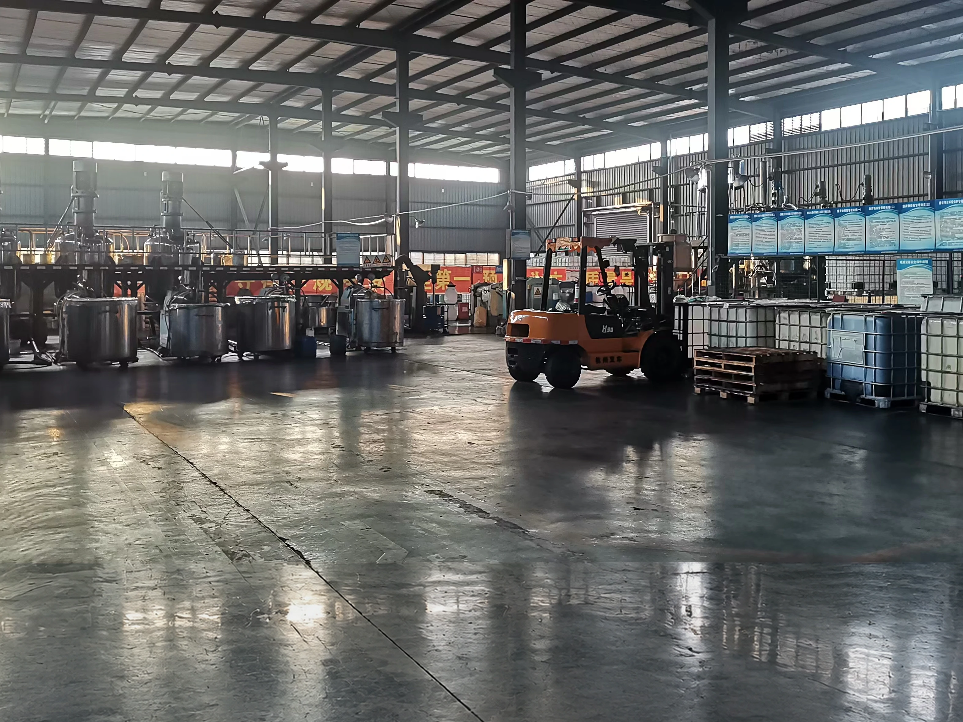 A forklift crossing the PrintBar plant floor, with pallets, IBC totes and mixing vessels alongside A forklift crossing the PrintBar plant floor, with pallets, IBC totes and mixing vessels alongside